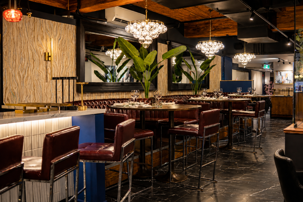 Luxury restaurant interior featuring custom architectural millwork, premium wood wall panels, bespoke banquette seating, decorative ceiling beams, and hospitality interior finishes by Boreal Architectural.