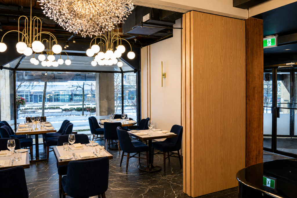 Luxury restaurant interior featuring custom oak veneer architectural wall panels, premium hospitality millwork, bespoke restaurant wood finishes, decorative architectural panel systems, and commercial interior craftsmanship by Boreal Architectural.