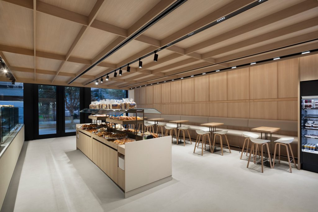 High-end architectural millwork with custom wood doors, feature wall systems, and integrated retail display cabinetry.