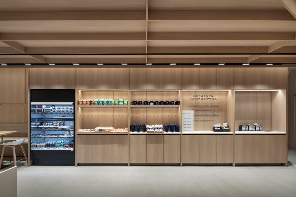 Custom architectural wood ceiling, commercial millwork, and bespoke retail fixtures creating a modern hospitality interior.