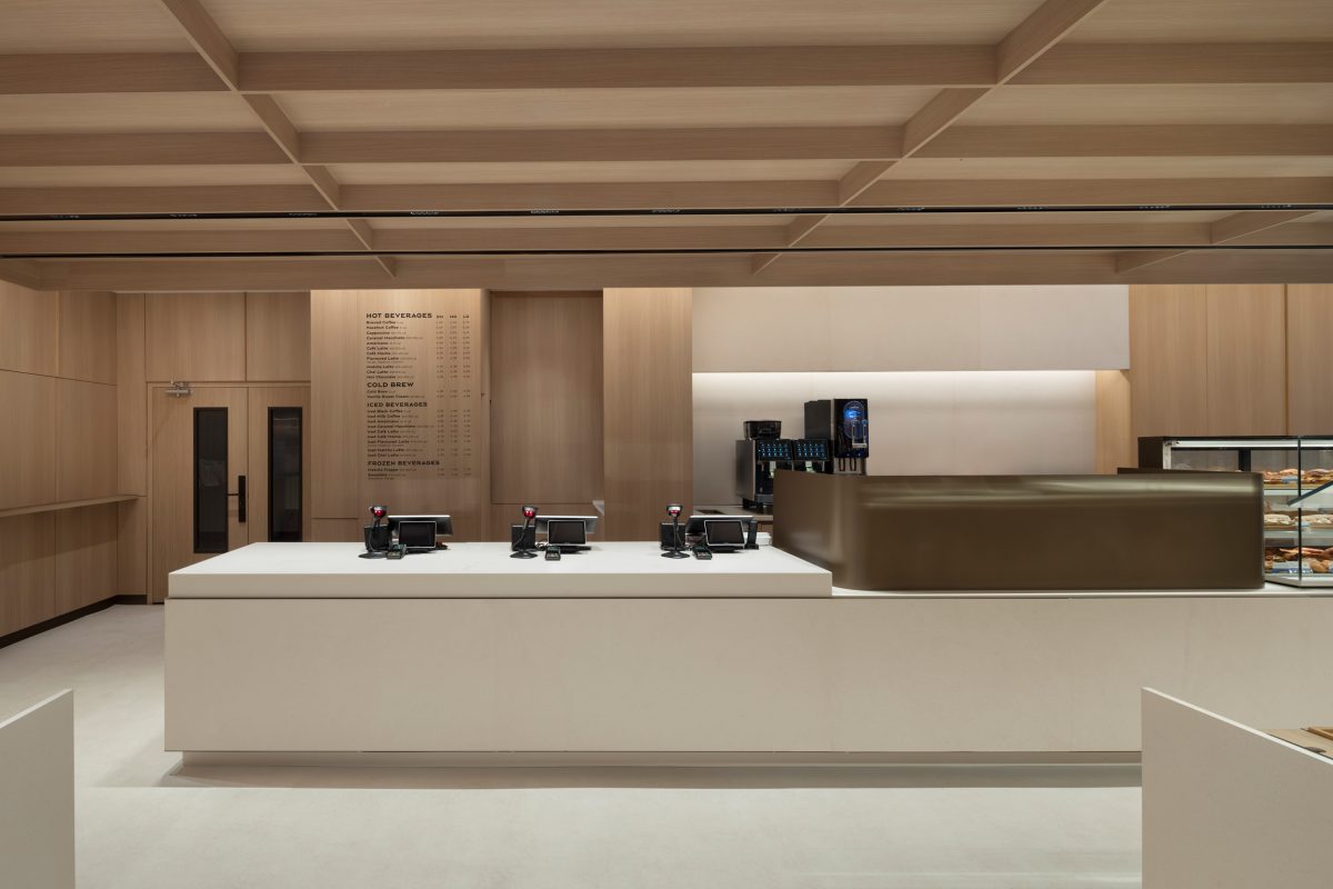 Premium architectural wood wall panels, custom millwork, and integrated commercial wood finishes in a contemporary bakery café.