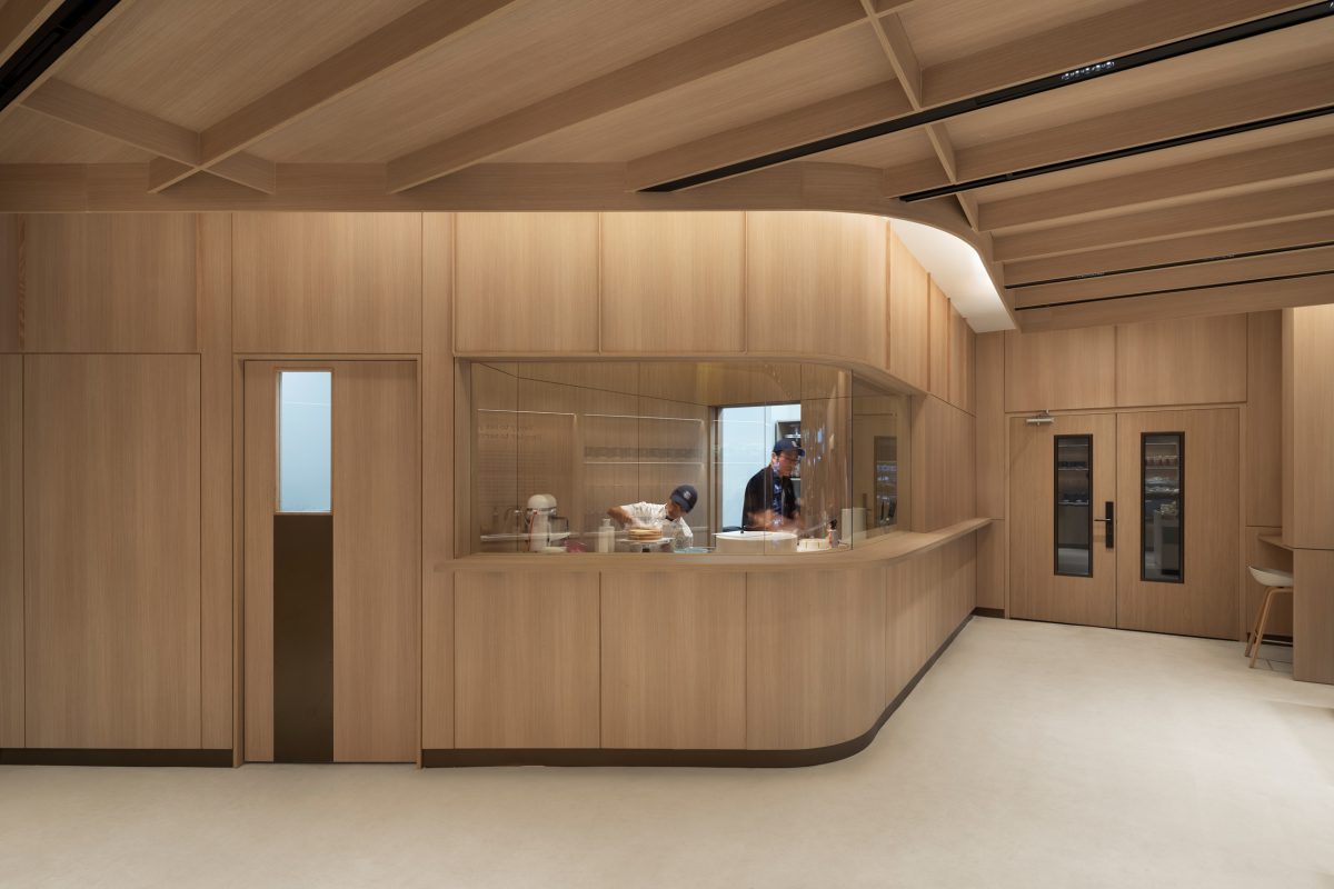 Architectural wood finishes and custom millwork creating a seamless hospitality-inspired commercial interior design.