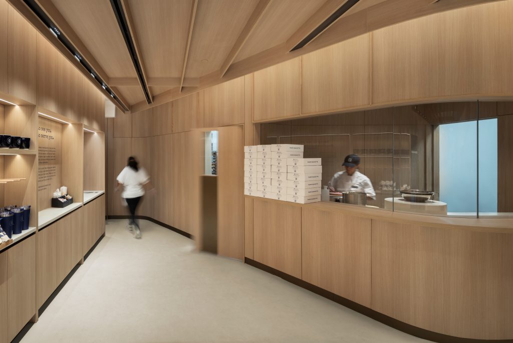 Luxury commercial interior featuring bespoke architectural millwork, wood feature walls, custom cabinetry, and retail fixtures.