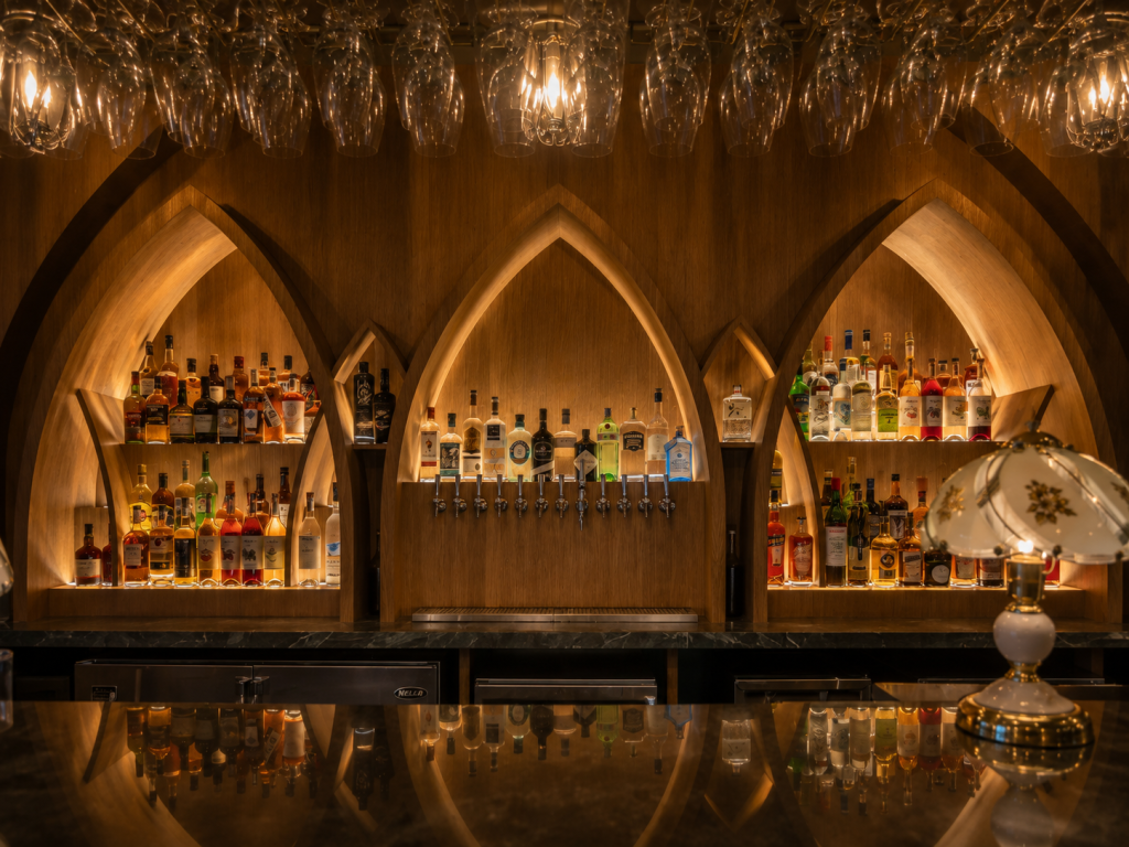 Custom restaurant bar and dining area featuring premium millwork, architectural wood finishes, custom cabinetry, integrated seating and hospitality interior construction.