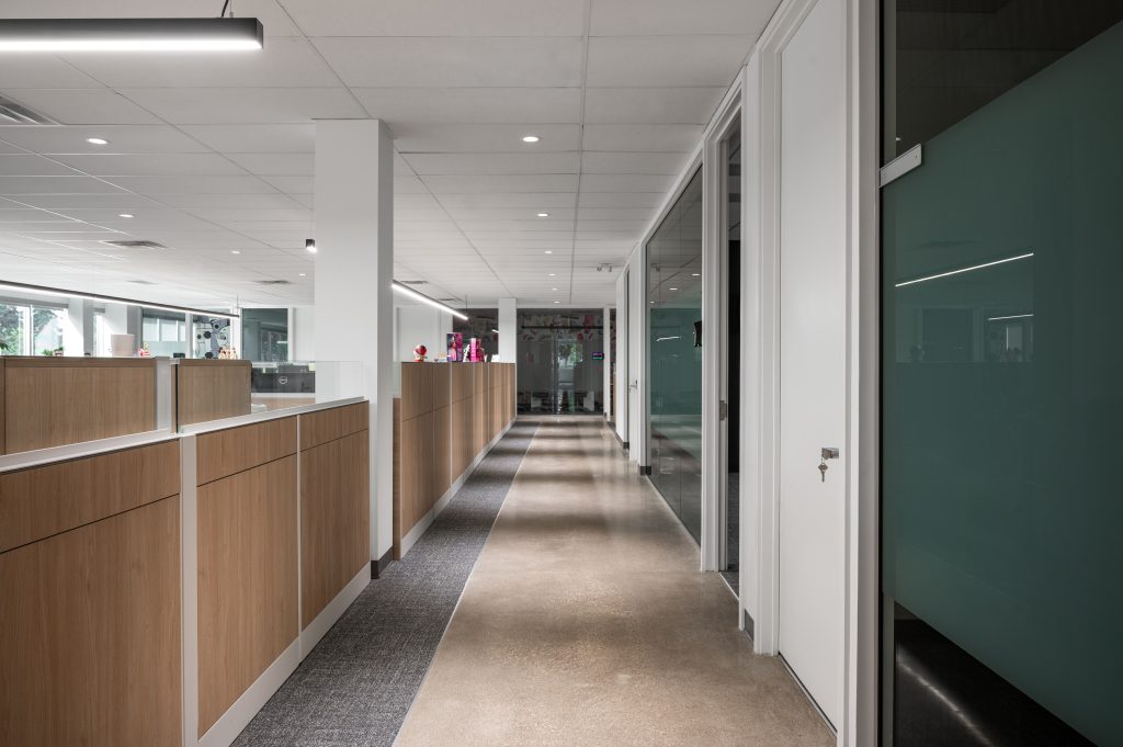 Architectural wood finishes and premium commercial millwork creating sophisticated corporate office interiors with custom cabinetry and built-in storage.