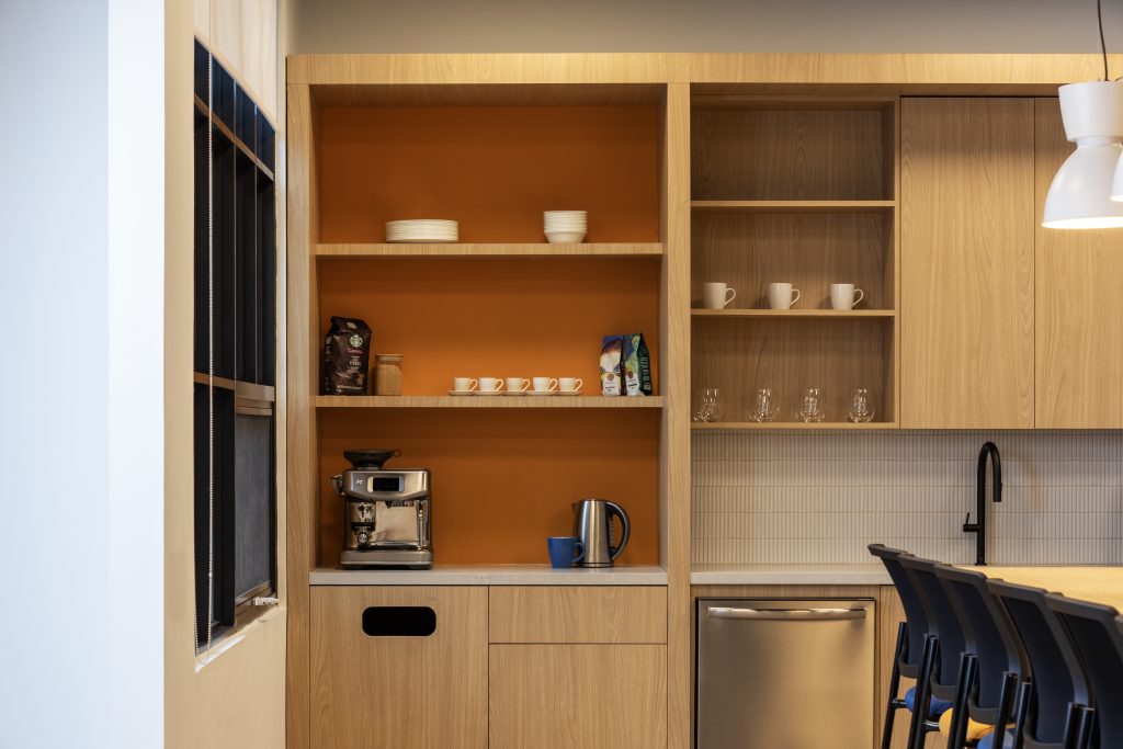 Custom coffee station with architectural wood millwork, open display shelving, integrated commercial cabinetry, premium office kitchenette finishes, and bespoke workplace storage by Boreal Architectural.