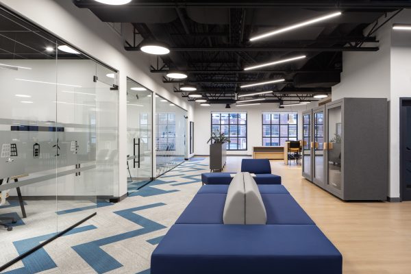 Modern corporate office interior featuring architectural glass partitions, custom wood millwork, integrated workplace finishes, premium commercial interiors, and collaborative office design constructed with Boreal Architectural millwork.