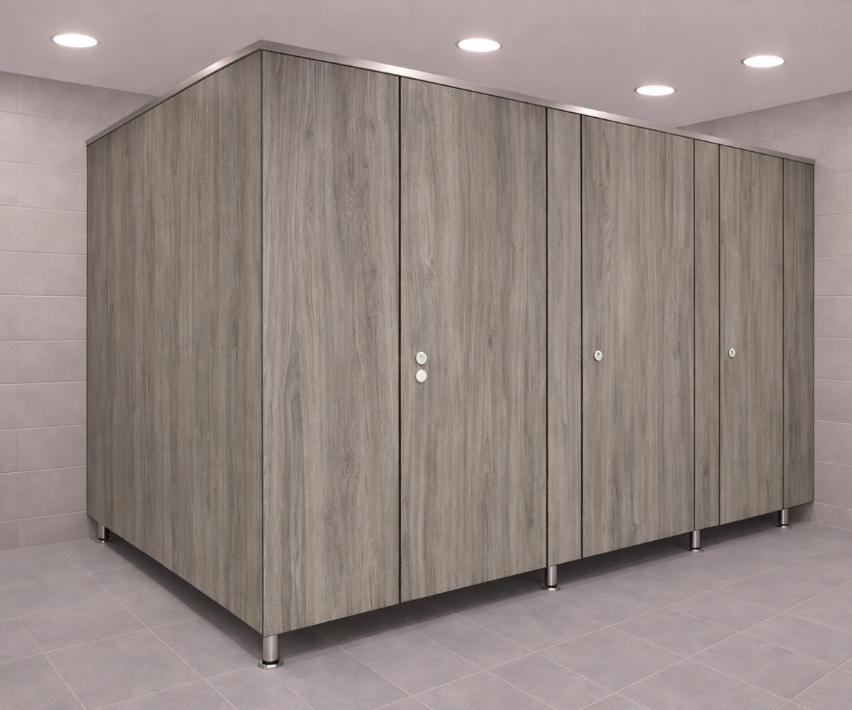 Aspen Series full privacy toilet partitions by Boreal Architectural in gray woodgrain finish with floor-mounted pedestal supports and stainless steel hardware in modern commercial washroom