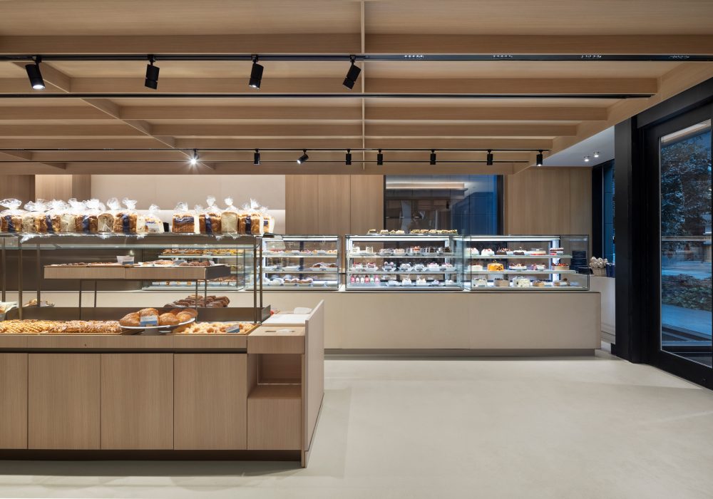Commercial retail space showcasing custom wood cabinetry, display cases and architectural ceiling features.