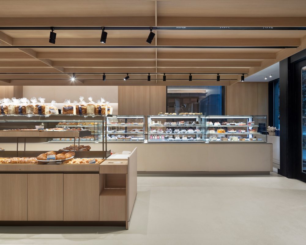 Commercial retail space showcasing custom wood cabinetry, display cases and architectural ceiling features.